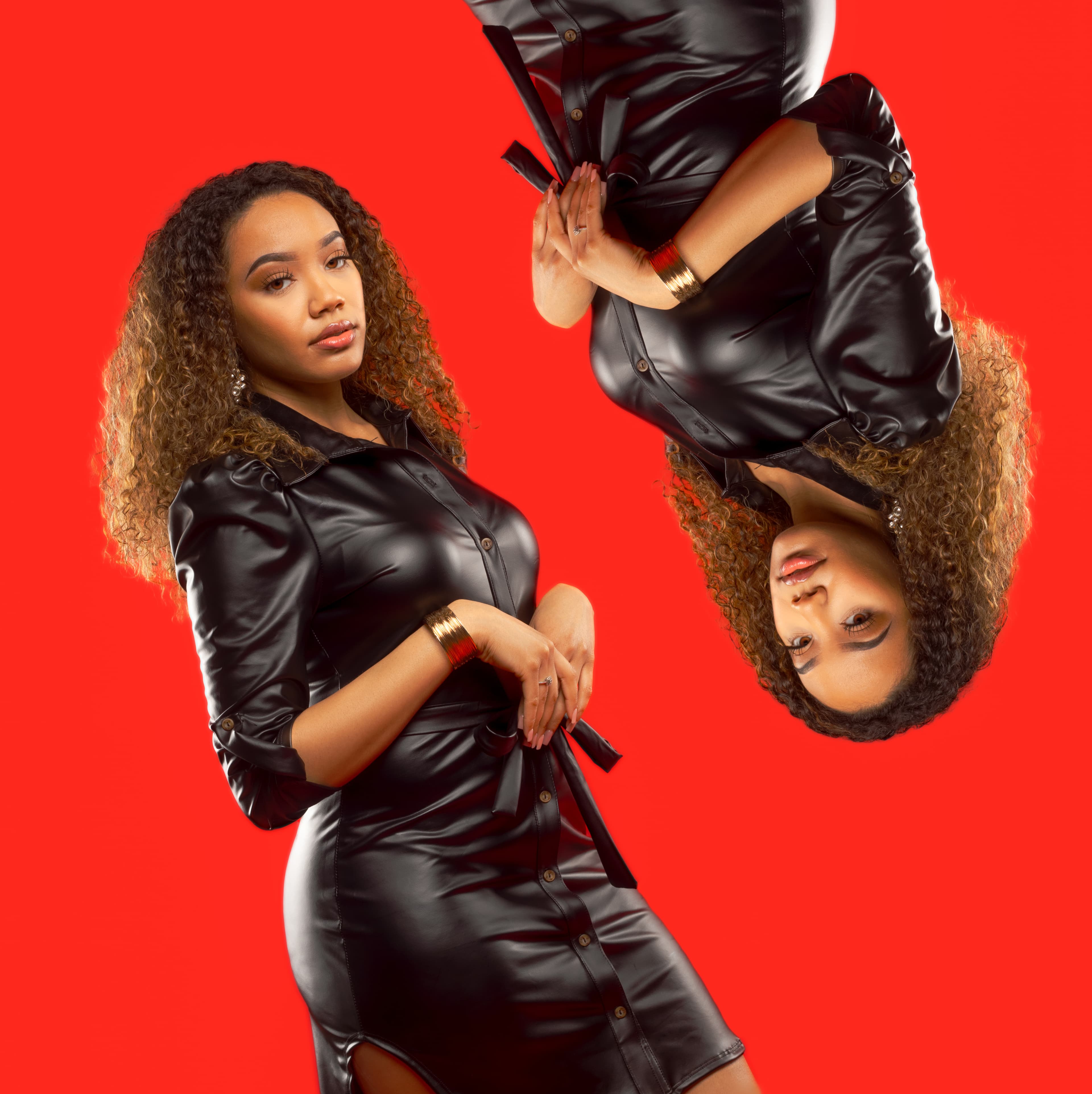 A woman in a black leather dress mirrored vertically against a solid bright red background.